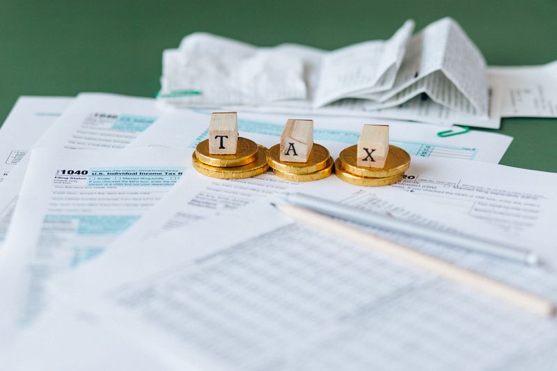 Close-up of tax forms, receipts, and coins symbolizing financial accounting and taxes